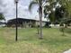 Expansive backyard with a screened porch, mature trees, and well-maintained landscaping offer a serene escape at 6488 Robinswood Ave, Brooksville, FL 34602