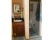 Compact bathroom featuring dark wood vanity, large mirror, and glass-enclosed shower at 6488 Robinswood Ave, Brooksville, FL 34602