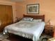 Comfortable bedroom with warm peach colored walls, wood furniture, closet, and soft quilt bedding at 6488 Robinswood Ave, Brooksville, FL 34602