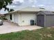 Exterior view of home featuring attached garage, gray shed, and green lawn at 6488 Robinswood Ave, Brooksville, FL 34602