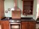 Kitchen featuring stainless steel oven, dark granite counters, and modern vent hood at 6488 Robinswood Ave, Brooksville, FL 34602
