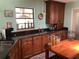 Spacious kitchen with dark wood cabinets, black granite countertops, and ample storage at 6488 Robinswood Ave, Brooksville, FL 34602