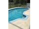 Backyard in-ground pool featuring in-pool steps, tiled trim, and lounge furniture at 6488 Robinswood Ave, Brooksville, FL 34602
