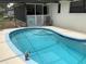 Refreshing in-ground pool in a screened enclosure offers a private oasis for relaxation at 6488 Robinswood Ave, Brooksville, FL 34602