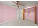 Pink bedroom features closet and ceiling fan at 6607 Larimer Dr, Tampa, FL 33615