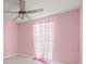 Bedroom with pink walls, window and ceiling fan at 6607 Larimer Dr, Tampa, FL 33615