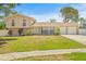 Inviting two-story home with a two-car garage, brick accents, and a lush green lawn at 6607 Larimer Dr, Tampa, FL 33615