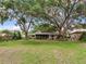 A sprawling lawn and mature trees offer a peaceful setting for this home's backyard at 7216 N Mobley Rd, Odessa, FL 33556
