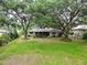 Spacious backyard with mature trees, providing ample shade and a serene outdoor living space at 7216 N Mobley Rd, Odessa, FL 33556