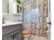This bathroom offers a pristine sink, cabinet, and tub with tasteful floral shower curtain at 7216 N Mobley Rd, Odessa, FL 33556