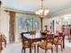 Dining room with a glass top table and six chairs, lit by a chandelier at 7216 N Mobley Rd, Odessa, FL 33556