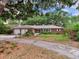 Charming single-story brick home with a two-car garage and mature trees at 7216 N Mobley Rd, Odessa, FL 33556