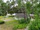 Charming home exterior with mature tree coverage and lush greenery, creating a private and inviting setting at 7216 N Mobley Rd, Odessa, FL 33556