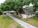A charming home and detached garage are nestled among lush greenery and mature trees at 7216 N Mobley Rd, Odessa, FL 33556