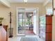 Warm foyer leading to screened porch with beige tile, coat rack and display cabinet at 7216 N Mobley Rd, Odessa, FL 33556
