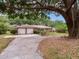 A well-maintained brick home with an attached garage and landscaped front yard at 7216 N Mobley Rd, Odessa, FL 33556