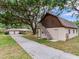 Detached garage with finished upper level space, complemented by mature landscaping and a long driveway at 7216 N Mobley Rd, Odessa, FL 33556