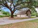 A detached garage with a finished upper level surrounded by mature trees providing shade and curb appeal at 7216 N Mobley Rd, Odessa, FL 33556