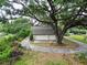 A detached garage with a finished upper level surrounded by mature trees providing shade and privacy at 7216 N Mobley Rd, Odessa, FL 33556