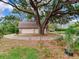 Detached garage with finished upper level with surrounding greenery, and driveway, offering space and functionality at 7216 N Mobley Rd, Odessa, FL 33556