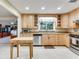 Well-lit kitchen featuring wood cabinets, stainless steel appliances, granite counters, and tile flooring at 7216 N Mobley Rd, Odessa, FL 33556