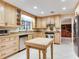 Bright kitchen with wooden cabinets, granite countertops, stainless steel appliances, and a central butcher block island at 7216 N Mobley Rd, Odessa, FL 33556