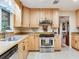 Bright kitchen featuring light wood cabinetry and stainless steel appliances at 7216 N Mobley Rd, Odessa, FL 33556