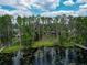 Lush waterfront property with mature trees, leading to a private dock on a tranquil lake at 7216 N Mobley Rd, Odessa, FL 33556