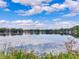 A beautiful lake view showing the calm water, blue sky, and puffy clouds reflecting on the water at 7216 N Mobley Rd, Odessa, FL 33556