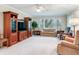Spacious living room with natural light, traditional furniture, and a large entertainment center at 7216 N Mobley Rd, Odessa, FL 33556