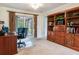 Office space with wood built-in shelves, a desk, and access to the patio at 7216 N Mobley Rd, Odessa, FL 33556