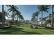Beautiful community park with sprawling green space, lush landscaping, and shady palm trees at 7610 Addison Ave, Bradenton, FL 34210