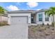 Charming single-story home boasts a gray tiled roof, two car garage, and attractive landscaping at 7610 Addison Ave, Bradenton, FL 34210