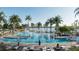 Large pool area featuring palm trees, lounge chairs, and a view of the lake in the background at 7610 Addison Ave, Bradenton, FL 34210