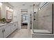 Modern bathroom featuring double sinks, white cabinetry, and a glass-enclosed shower at 7614 Addison Ave, Bradenton, FL 34210