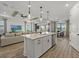 Open-concept kitchen with an island, stainless steel appliances, and seamless flow to the living and dining areas at 7614 Addison Ave, Bradenton, FL 34210