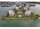 Aerial view of a luxury condo community with a central pool and manicured lawns on a peninsula surrounded by water at 7922 Sailboat Key S Blvd # 608, South Pasadena, FL 33707