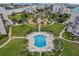 Aerial view of a square community pool featuring lounge chairs, umbrellas, and lush greenery at 7922 Sailboat Key S Blvd # 608, South Pasadena, FL 33707