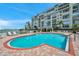 Inviting outdoor pool area with lounge chairs, lush greenery, and serene waterfront views at 7922 Sailboat Key S Blvd # 608, South Pasadena, FL 33707