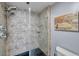 Walk-in shower features a glass door, shower caddy, and unique, neutral-colored tiling at 7922 Sailboat Key S Blvd # 608, South Pasadena, FL 33707