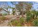 The backyard features mature trees, a stairway, and gravel landscape at 824 35Th Avenue W Dr, Palmetto, FL 34221