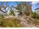 The backyard features mature trees, a stairway, and gravel landscape at 824 35Th Avenue W Dr, Palmetto, FL 34221