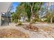 The backyard features mature trees, a stairway, and gravel landscape at 824 35Th Avenue W Dr, Palmetto, FL 34221