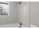 This bathroom features white tiled walls above a tub with brushed nickel fixtures and a shower head at 824 35Th Avenue W Dr, Palmetto, FL 34221