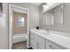 Bright bathroom featuring a white vanity with a framed mirror and a peek into the tiled shower/tub at 824 35Th Avenue W Dr, Palmetto, FL 34221