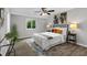 Cozy bedroom with gray walls, ceiling fan, and a comfortable bed with colorful accent pillows at 824 35Th Avenue W Dr, Palmetto, FL 34221