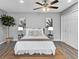 Bright bedroom featuring a ceiling fan and a queen bed with woven rug and soft lamps at 824 35Th Avenue W Dr, Palmetto, FL 34221
