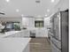 Modern kitchen features white cabinetry, stainless steel appliances and a large center island with a view from the window at 824 35Th Avenue W Dr, Palmetto, FL 34221