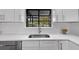 Kitchen features stainless steel appliances, white cabinets, quartz countertops and stainless steel sink under a window at 824 35Th Avenue W Dr, Palmetto, FL 34221
