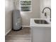 Bright laundry room with a stainless steel sink, modern faucet, and a window above the water heater at 824 35Th Avenue W Dr, Palmetto, FL 34221